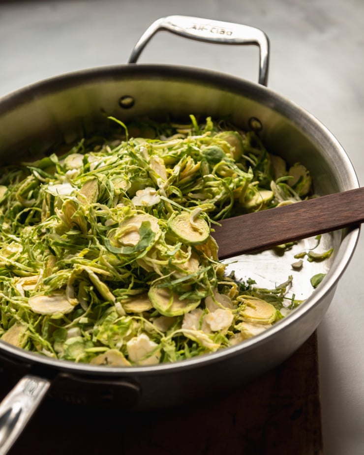 A 3/4 angle shot shows sliced brussels sprouts in a pan.