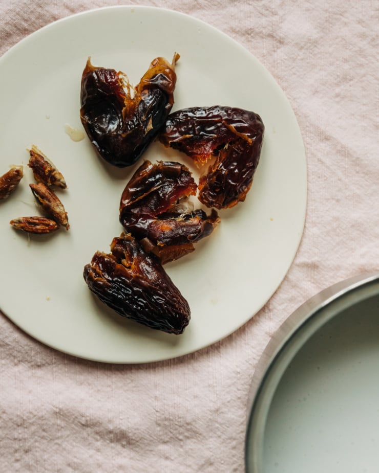 An overhead shot of pitted dates in a plate.