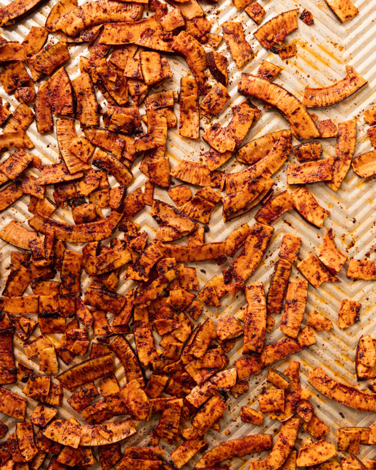 An overhead shot shows a baking sheet filled with crispy and smoky roasted coconut chips.