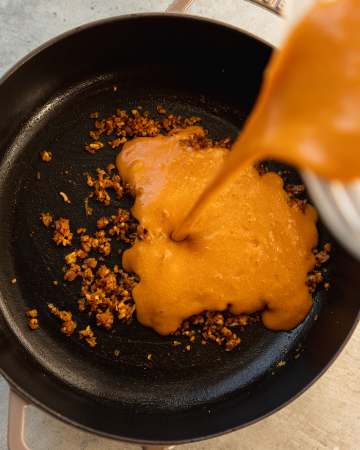 An overhead shot shows a puréed butternut squash sauce being poured into a braiser pot with sautéed shallots, ginger, and garlic.