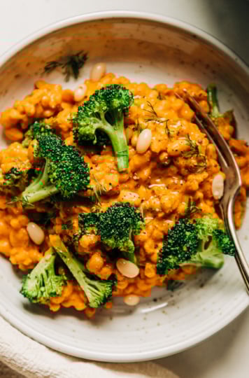 An up close, overhead shot of an individual serving of a creamy broccoli, barley and white bean dish.