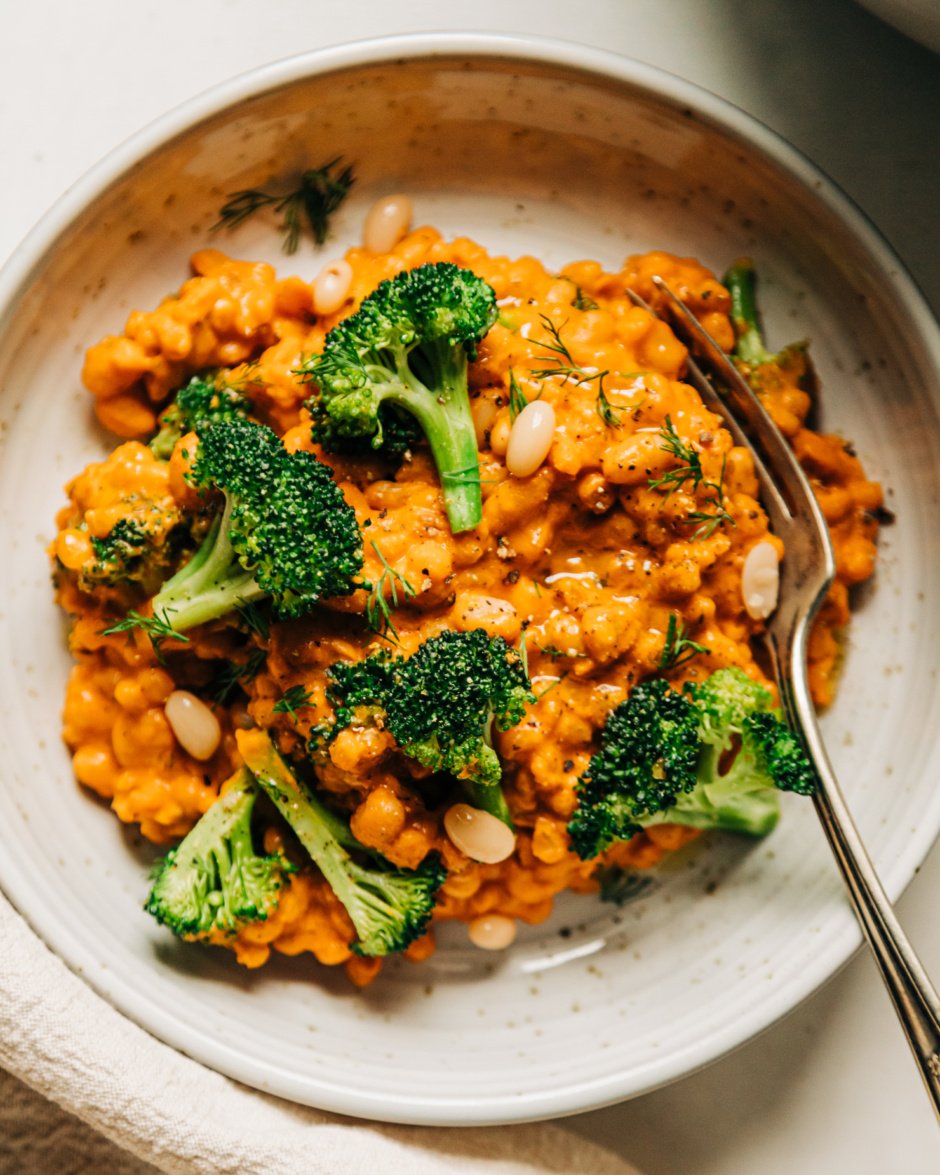 An up close, overhead shot of an individual serving of a creamy broccoli, barley and white bean dish.