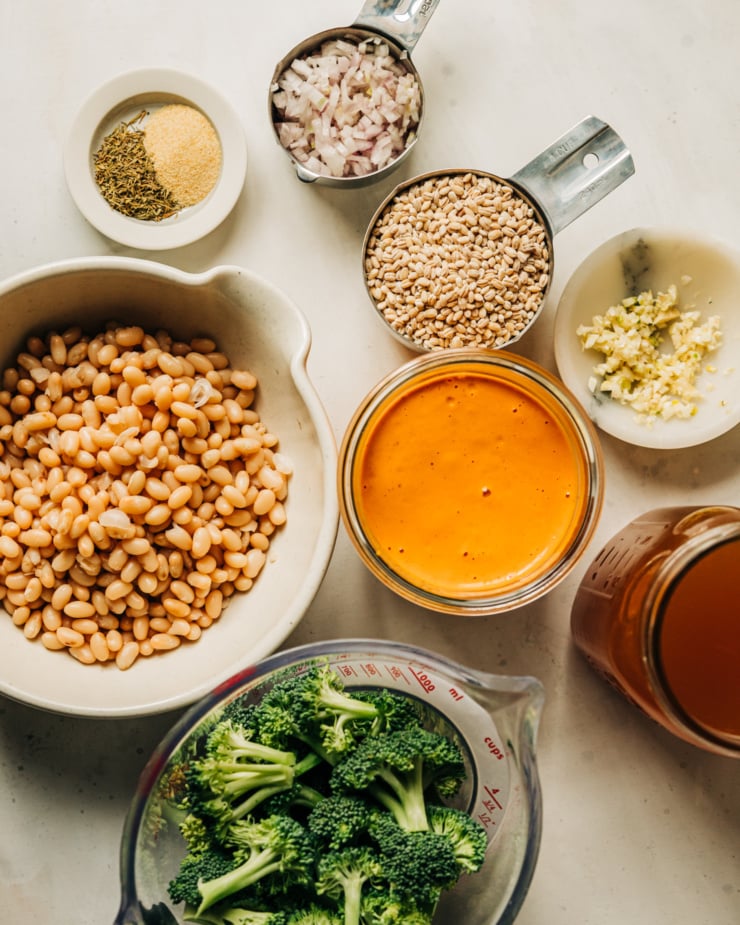 An overhead shot of prepped ingredients for a vegan broccoli and barley dish with white beans.