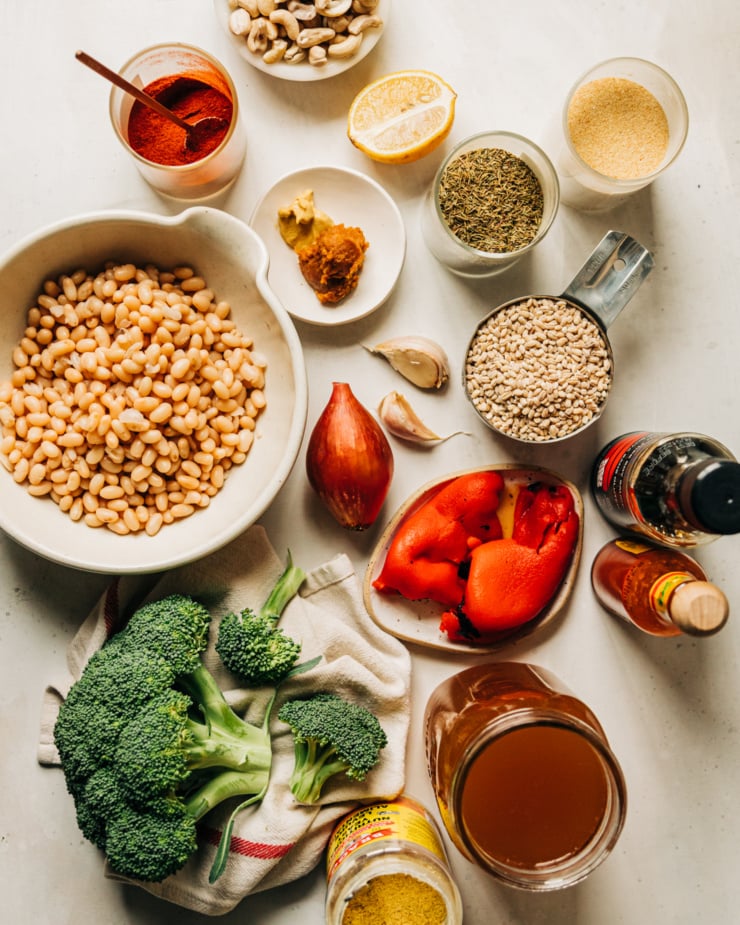 An overhead shot of ingredients used in a vegan broccoli and barley dish with white beans.
