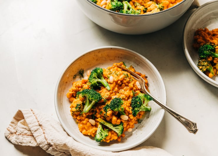 An overhead shot of an individual serving of a creamy broccoli, barley and white bean dish.