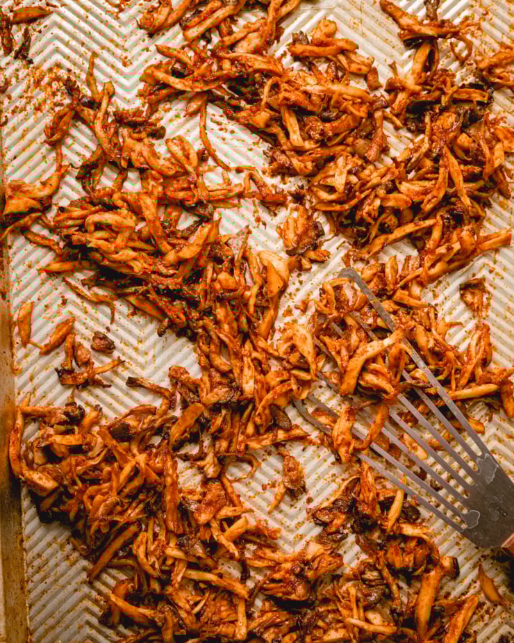 An overhead shot of barbecue sauce-coated shredded mushrooms that have been roasted in the oven.