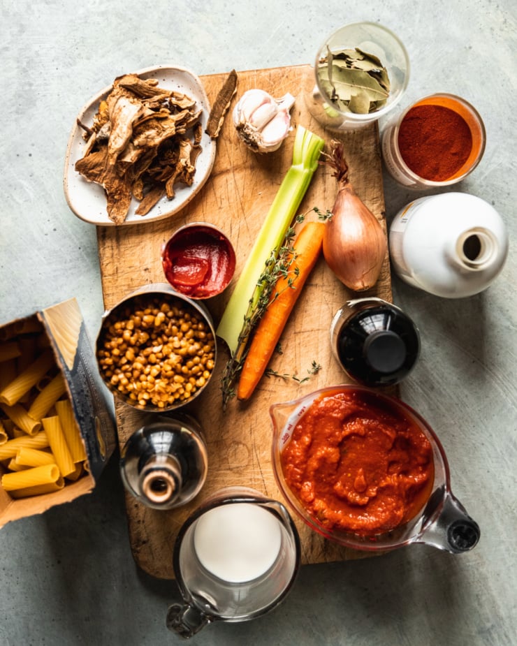 An overhead image shows ingredients used for a vegan, 30-minute lentil bolognese pasta.