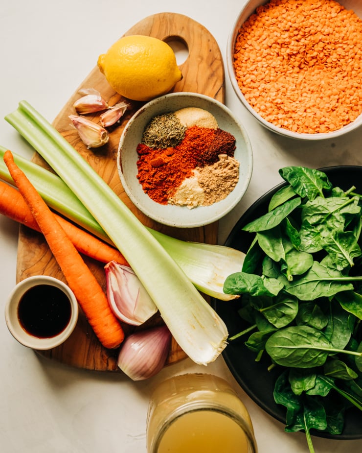 An overhead shot shows ingredients for a lemony lentil soup with spinach and 7 spices.