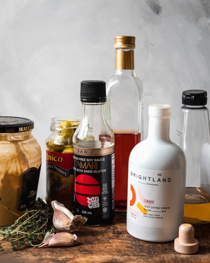 A head-on shot of ingredients used for a red wine vinegar and thyme dressing.
