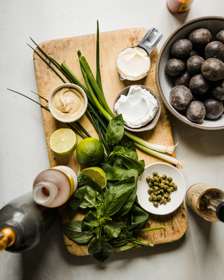 An overhead shot shows ingredients for a potato dish served with vegan green goddess dressing.