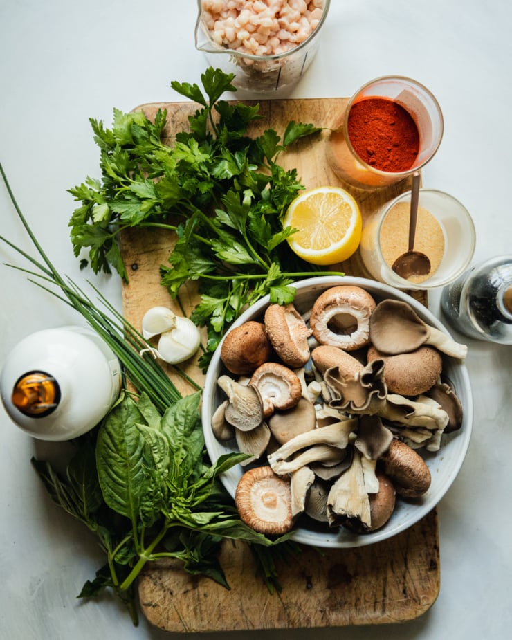 An overhead shot shows raw ingredients for an herby whipped white bean dip plus smoky grilled mushrooms to go on top.