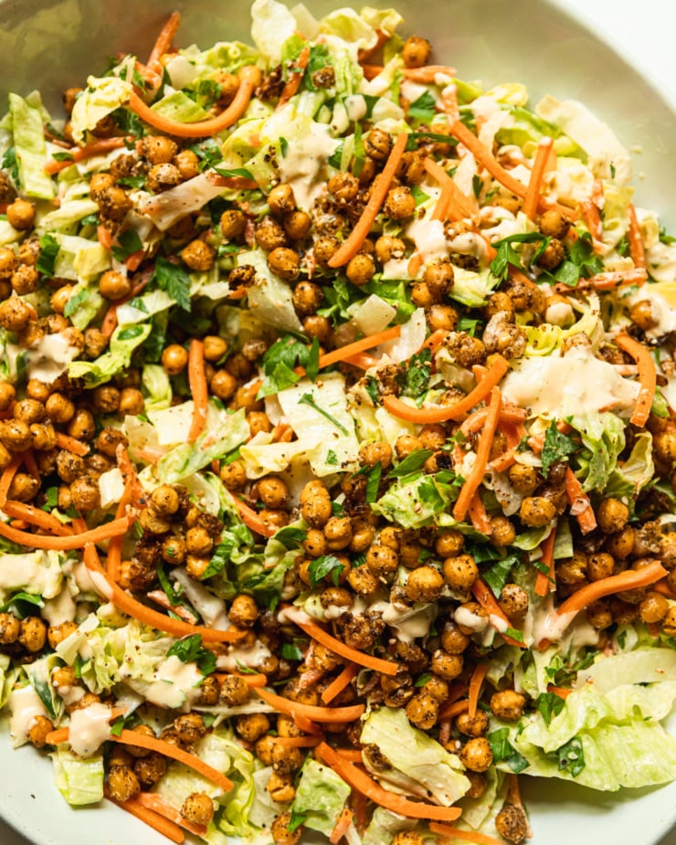 An up close, overhead shot shows a green salad topped with crispy za'atar chickpeas.