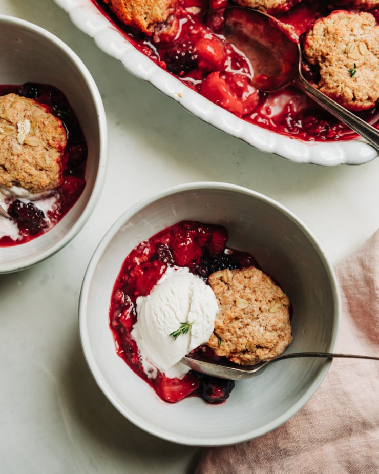 An overhead shot shows a serving of vegan berry cobbler with a scoop of ice cream.