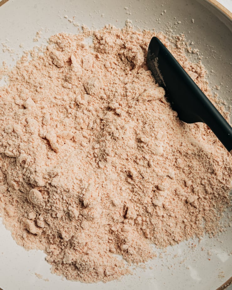 An overhead shot shows the wet sandy texture of flour that has had vegan butter worked into it evenly.