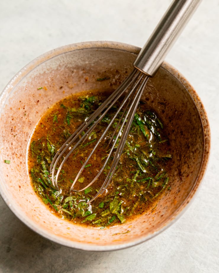 An overhead shot shows a whisked together orange and mint dressing.