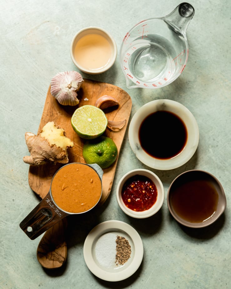 An overhead shot shows ingredients used in a creamy vegan peanut sauce.