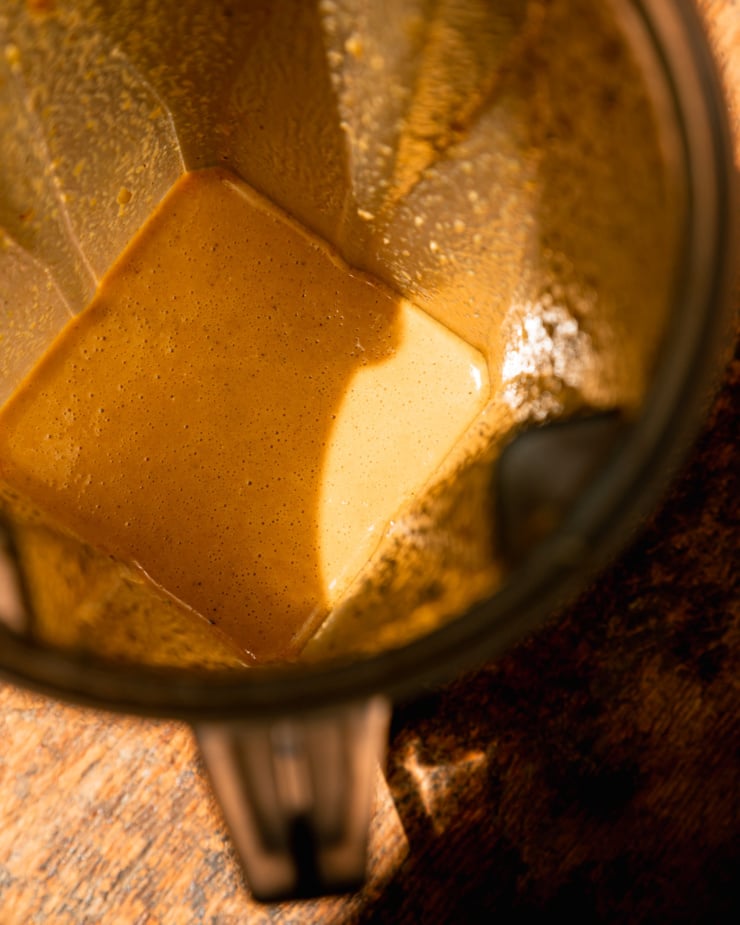 An overhead shot of a salad dressing that's just been blended up, still in the blender pitcher. The salad dressing has a slightly creamy appearance.