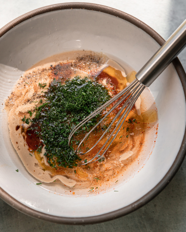 An overhead shot shows ingredient sin the bowl for a creamy sauce recipe, prior to whisking to combine.