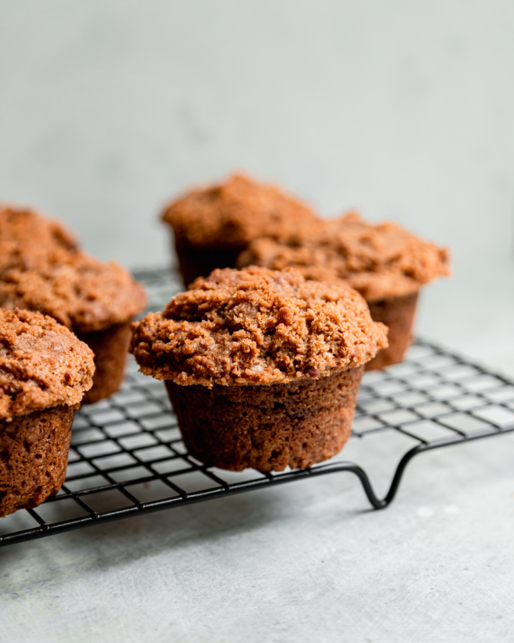 A head-on shot shows vegan coffee cake muffins cooling on a wire rack.
