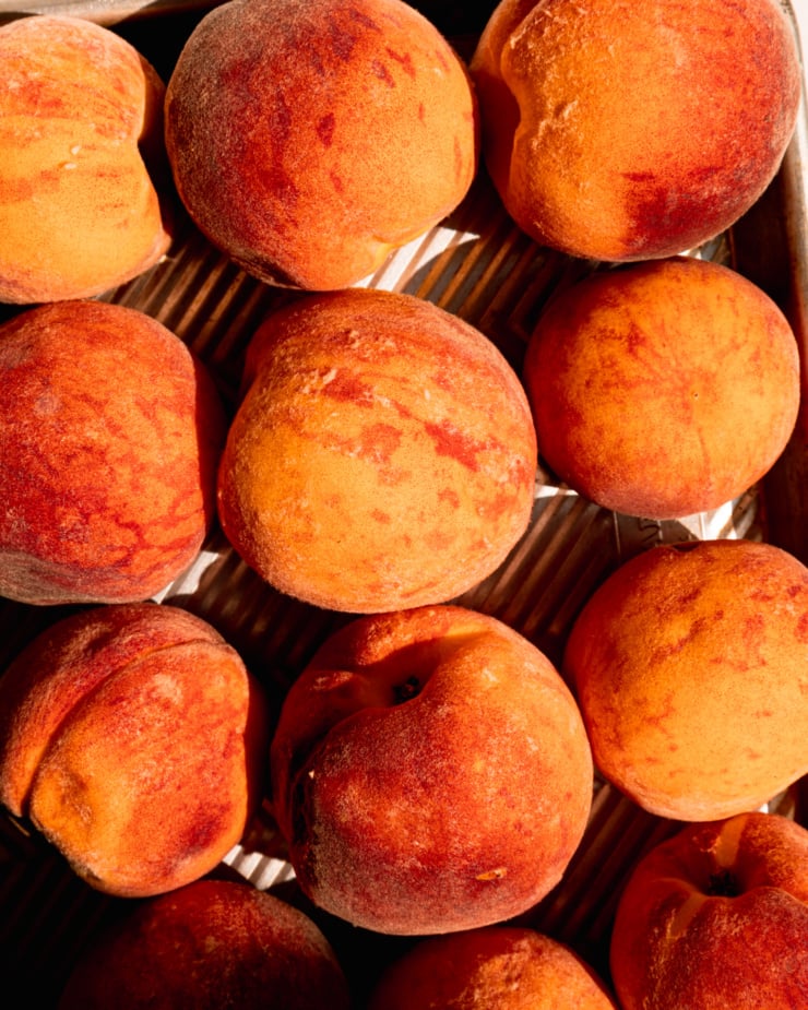 An overhead shot of peaches in direct sunlight.