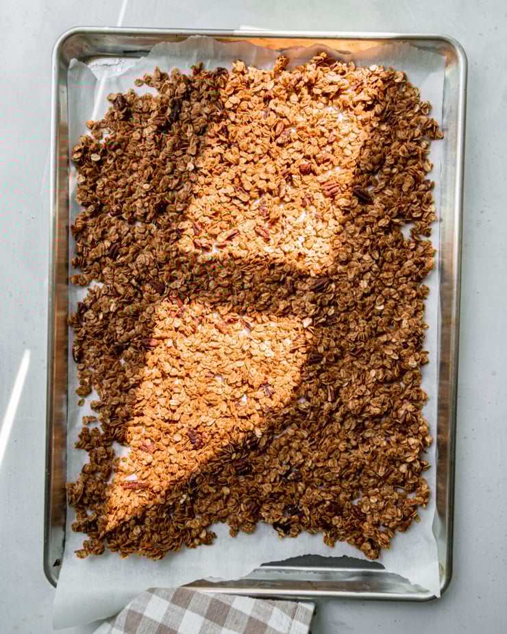 An overhead shot shows a baking sheet filled with freshly baked apple cinnamon granola.