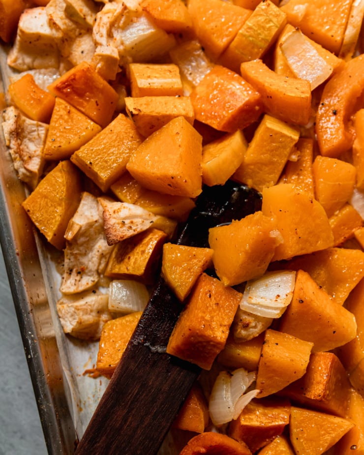 An up close, overhead shot shows roasted, soft butternut squash, apples, and onions.