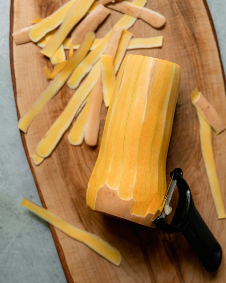 An overhead shot shows a butternut squash that has been peeled