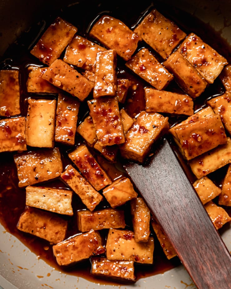 An overhead, up close shot shows saucy spicy maple tofu pieces.