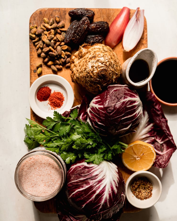 An overhead shot shows ingredients for a celery root radicchio salad with warm date dressing.
