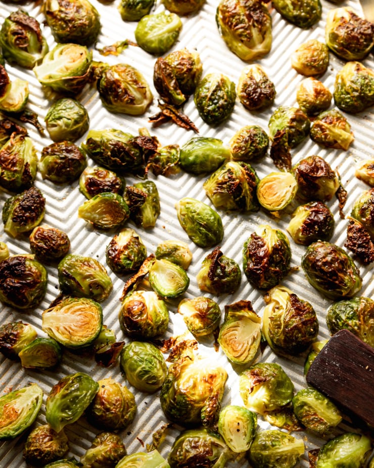 An overhead shot shows roasted Brussels sprouts on a baking sheet.