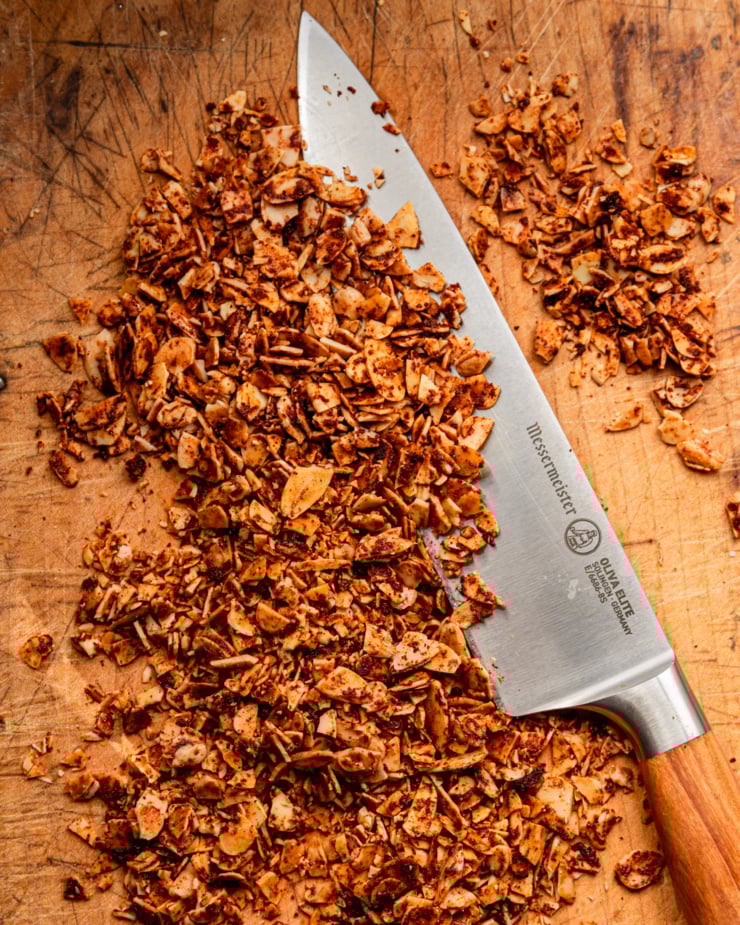 An overhead shot shows a knife and finely chopped smoky maple almond slices.
