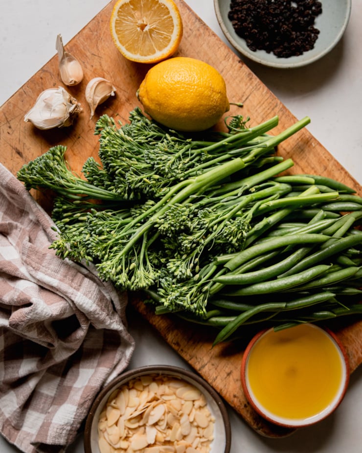 An overhead shot shows ingredients for a sautéed veggie side dish of broccolini and green beans.