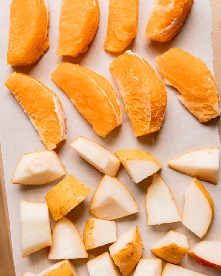 An overhead shot shows frozen peeled orange segments and frozen chunks of pear.