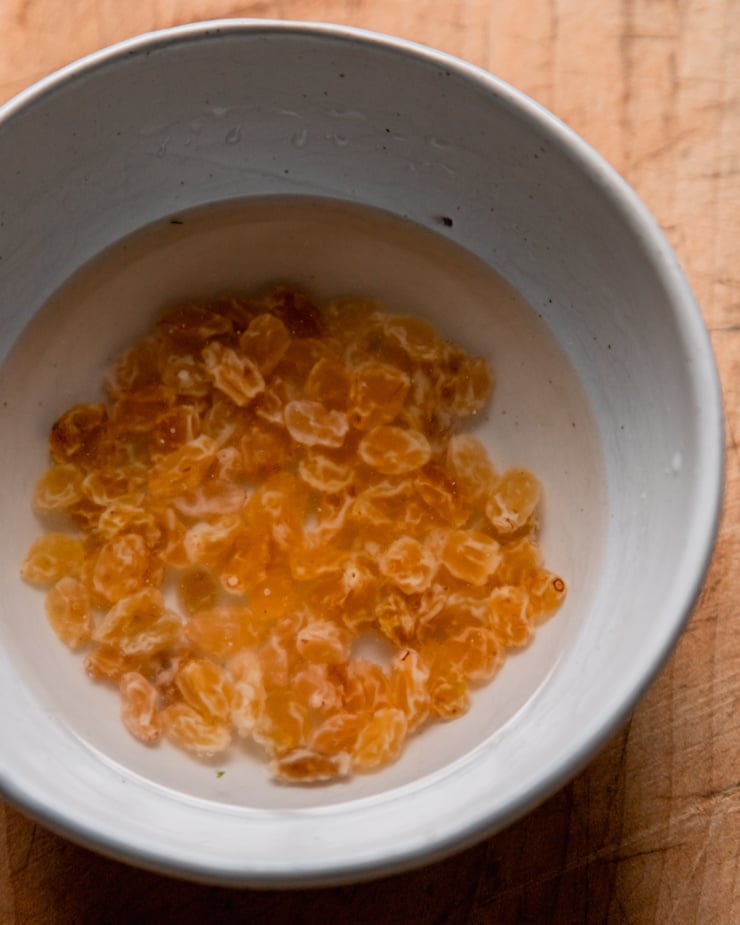 An overhead shot shows golden raising soaking in a bowl of water.