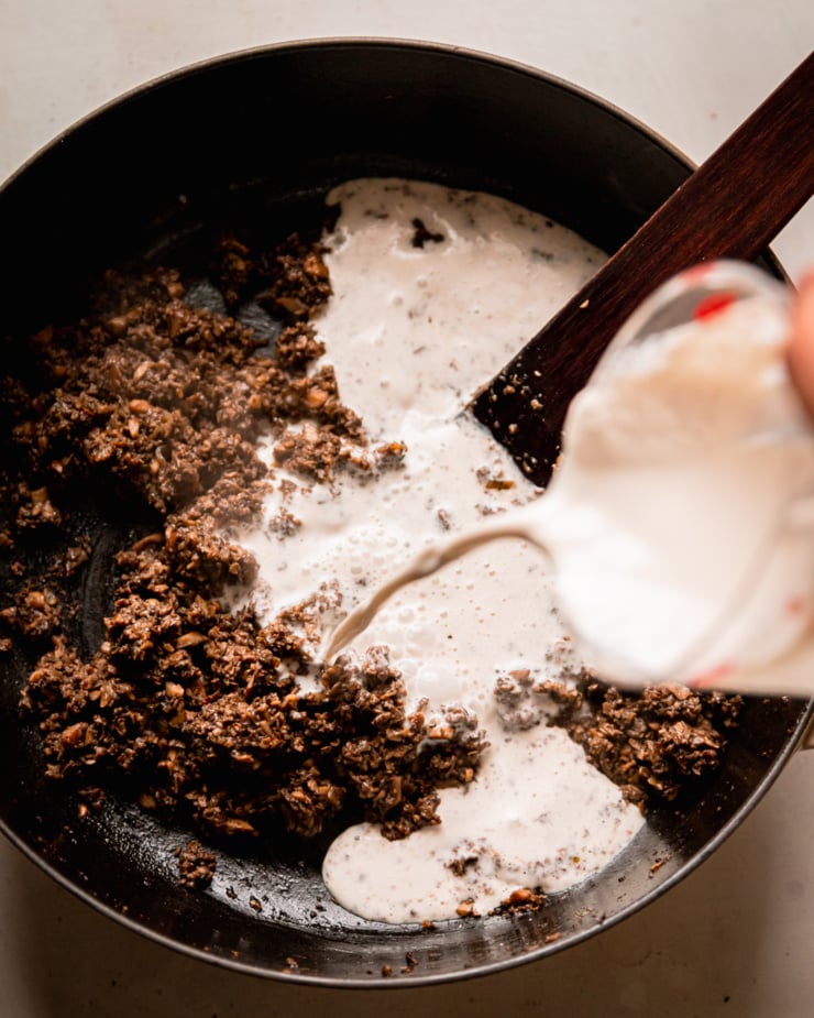 An overhead shot shows plant-based "cream" being poured into a pan with mushroom duxelles.