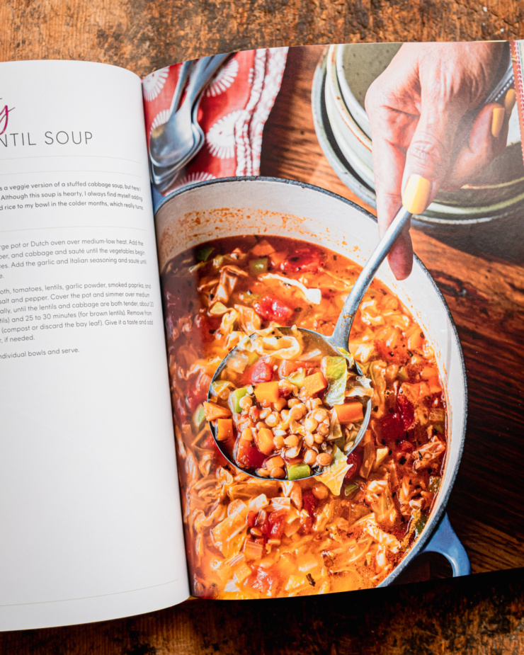 An overhead shot shows a cabbage and lentil soup recipe photo in the cookbook "Supper with Love" by Michelle Braxton.
