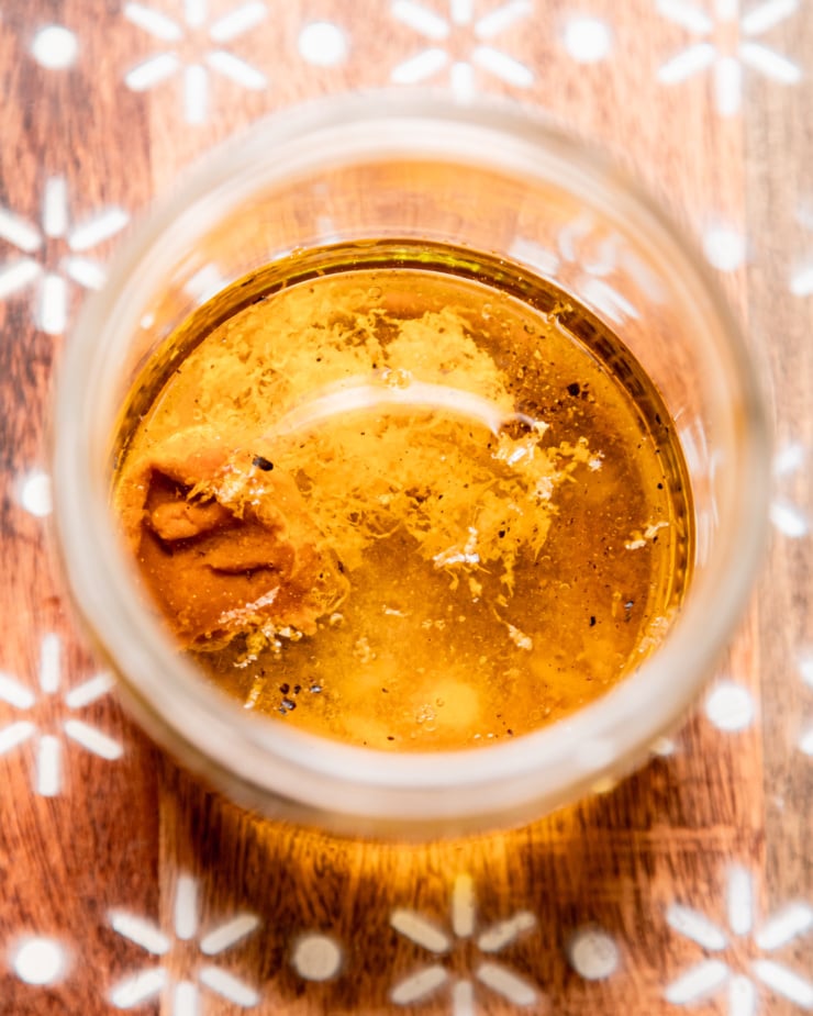 An overhead shot shows a jar with lemony miso salad dressing ingredients inside.