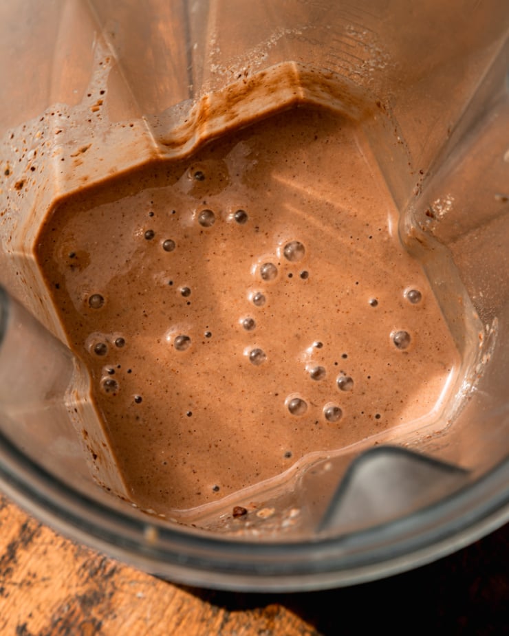 An overhead shot shows a chocolaty smoothie blend in a blender container.