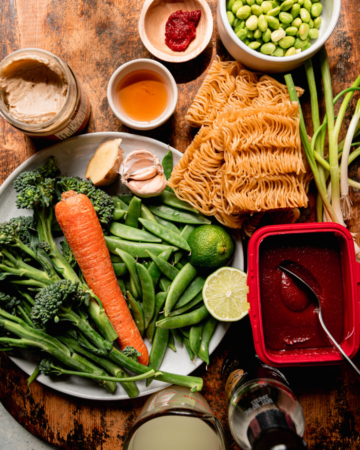 An overhead shot shows ingredients used for a vegan noodle stir fry dish.