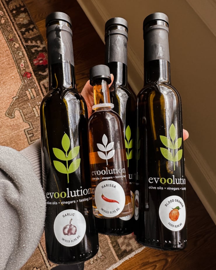 An overhead shot shows a bunch of different infused olive oils in glass bottles.