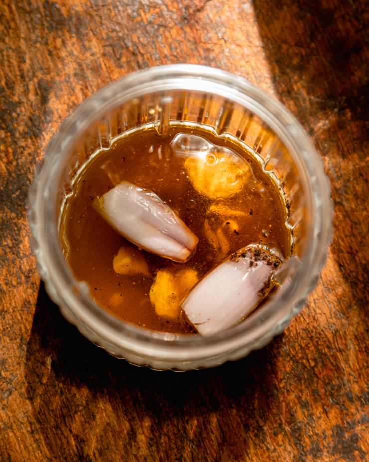 An overhead shot shows ingredients for a creamy lemon mint poppy seed dressing in a small blender jar.