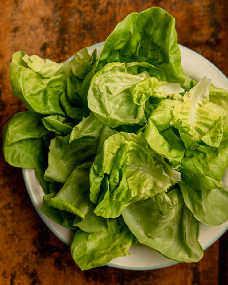 An overhead shot shows a bowl of butter lettuce leaves.