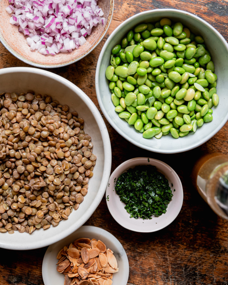 An overhead shot shows prepped ingredients in bowls for a salad.