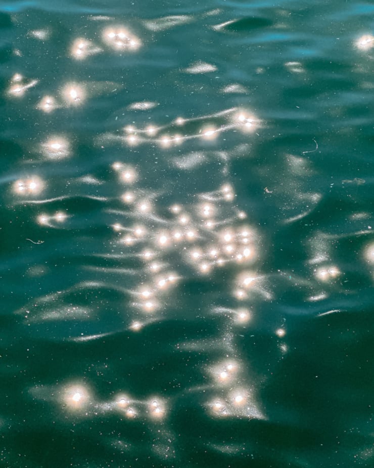 An overhead shot shows sparkly ripples on a lake in bright sunlight.