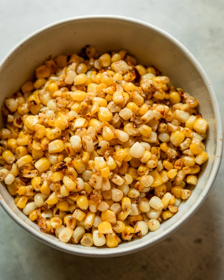 An overhead shot shows a bowl filled with lightly charred corn kernels.