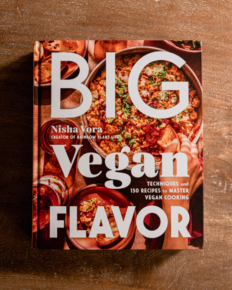An overhead shot shows the cookbook "Big Vegan Flavor" by Nisha Vora