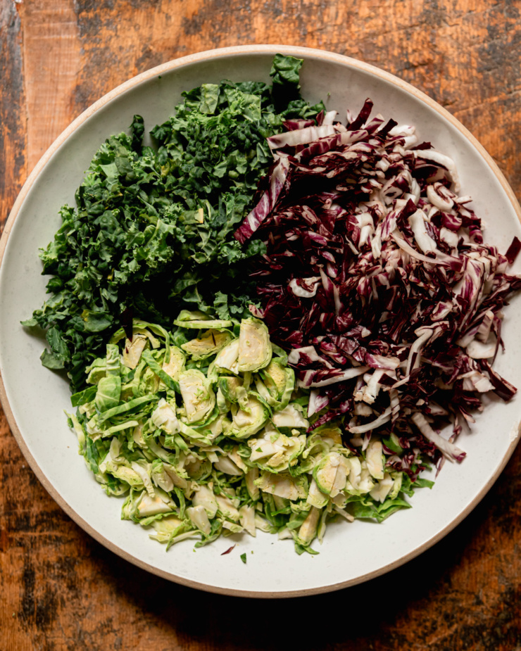 An overhead shot shows a wide bowl with shredded kale, radicchio, and brussels sprouts.