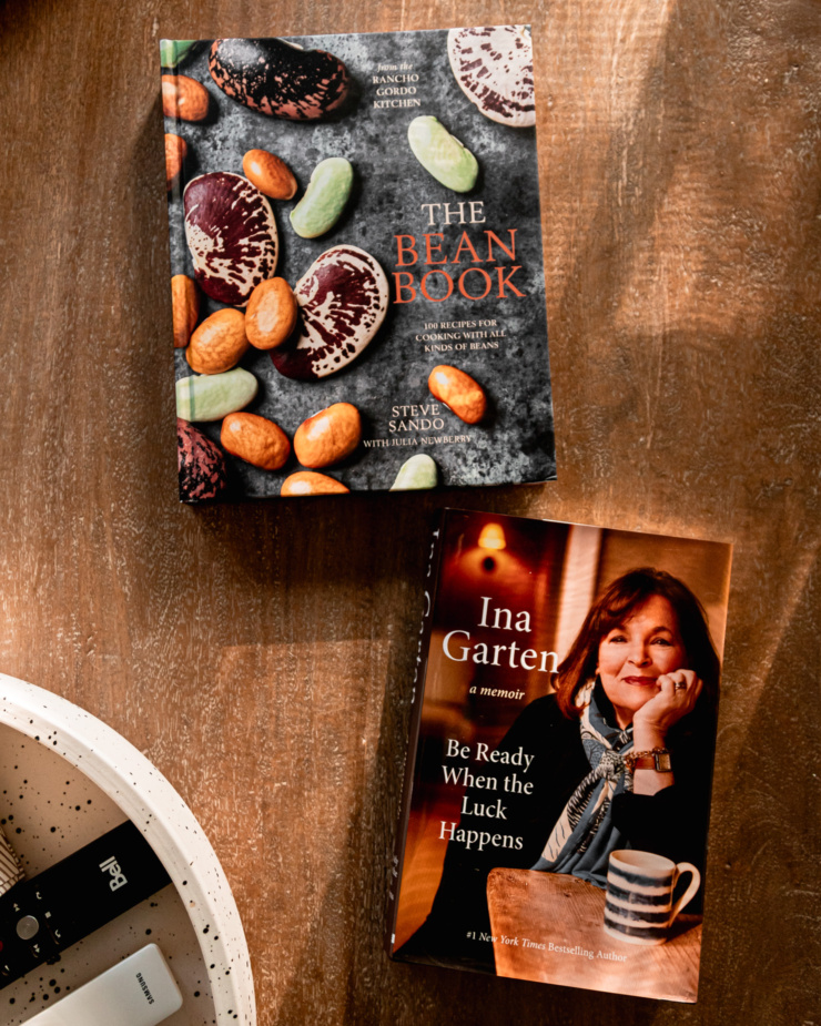 An overhead shot shows "The Bean Book" by Steve Sando and Ina Garten's memoir on a wood table.