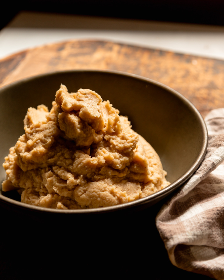 A head-on shot shows a pile of mashed cauliflower in a serving bowl.