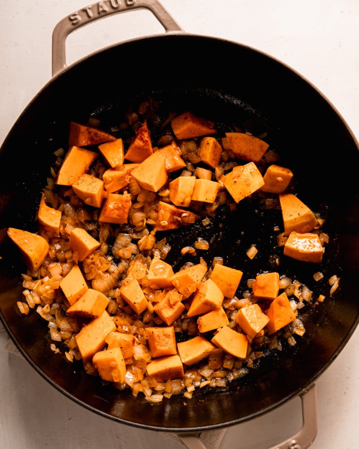 An overhead shot shows sautéed onions and cubed butternut squash in a braiser pot.